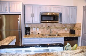 A kitchen with white cabinets, stainless steel appliances, a granite countertop, and a dishwasher. - I10 - Apt|Patio|11mi to Convention Ctr|Sleeps 2 (Irving)