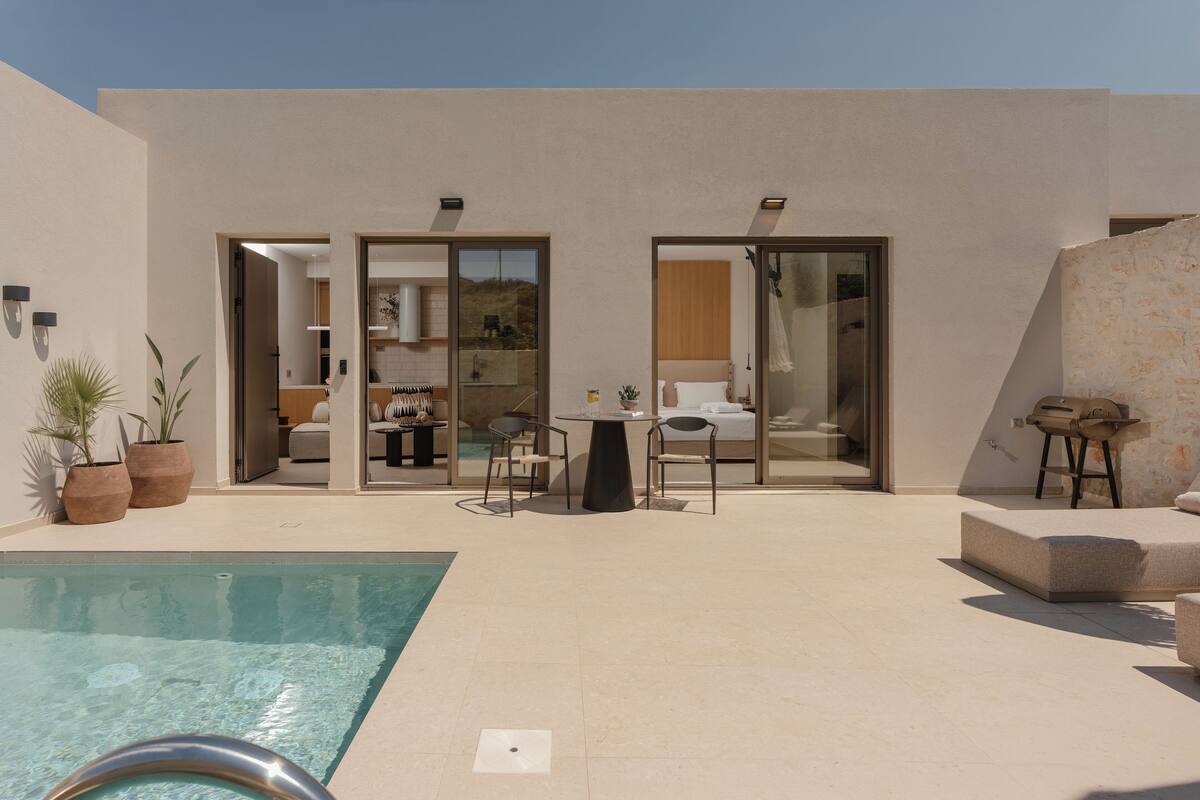 A modern outdoor pool area with a lounge chair, a table, and a sofa.