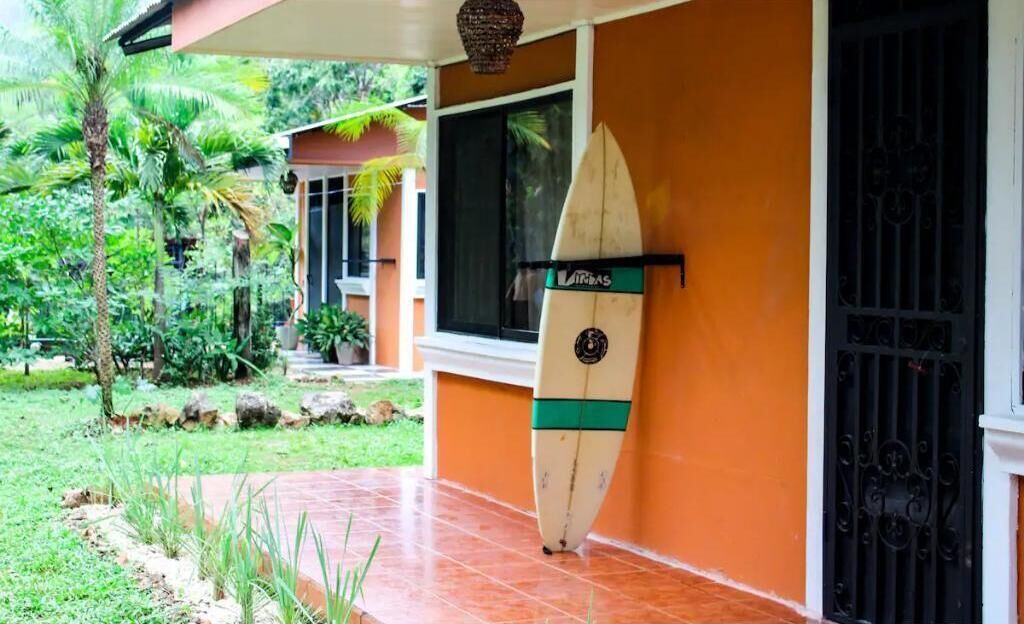 Una tavola da surf appoggiata a un edificio con una finestra e un'entrata.