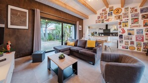 A modern living room with a sectional sofa, a coffee table, and a dining area.