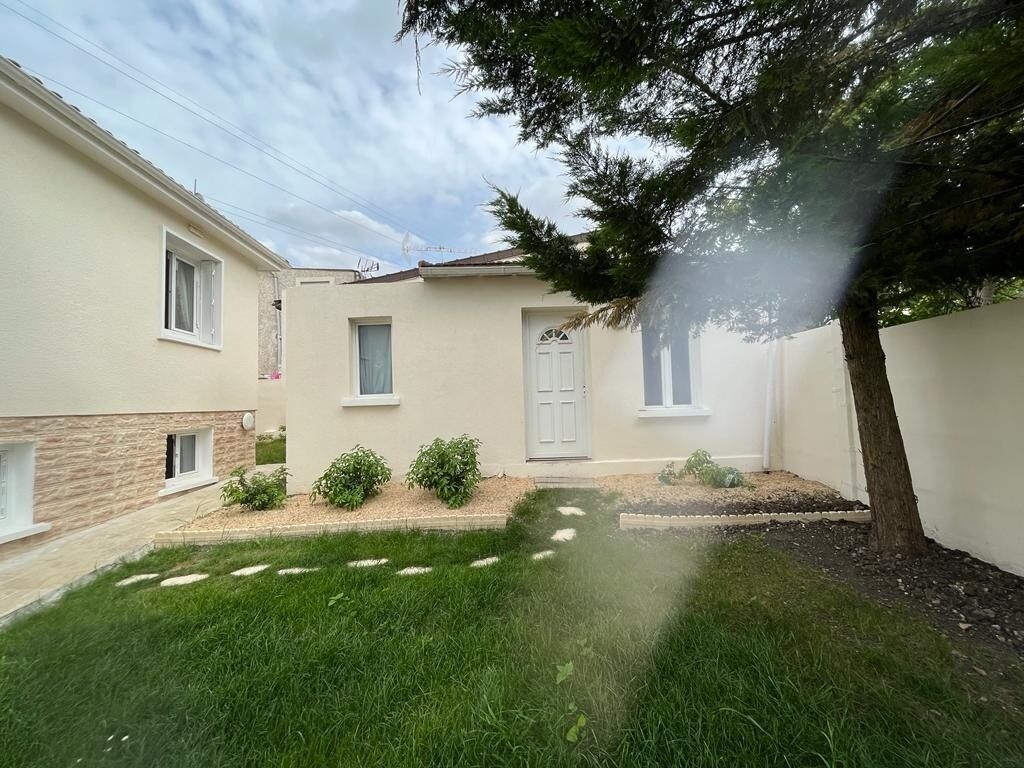 Ein zweistöckiges Haus mit Vorgarten, Tür und Fenster.