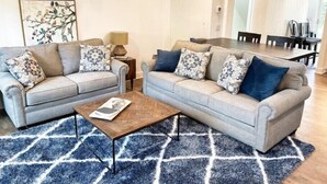 A living room with two grey sofas, a coffee table, and a blue patterned rug. - BV getaway 3 bedroom style

 (Bella Vista)