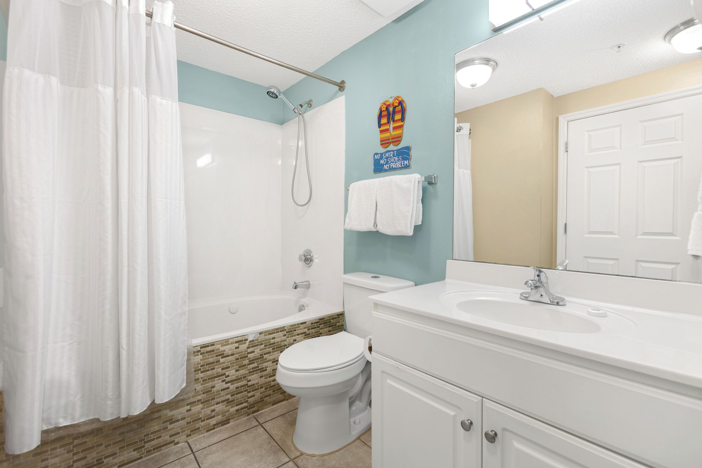 Une salle de bain avec douche, toilettes et lavabo.