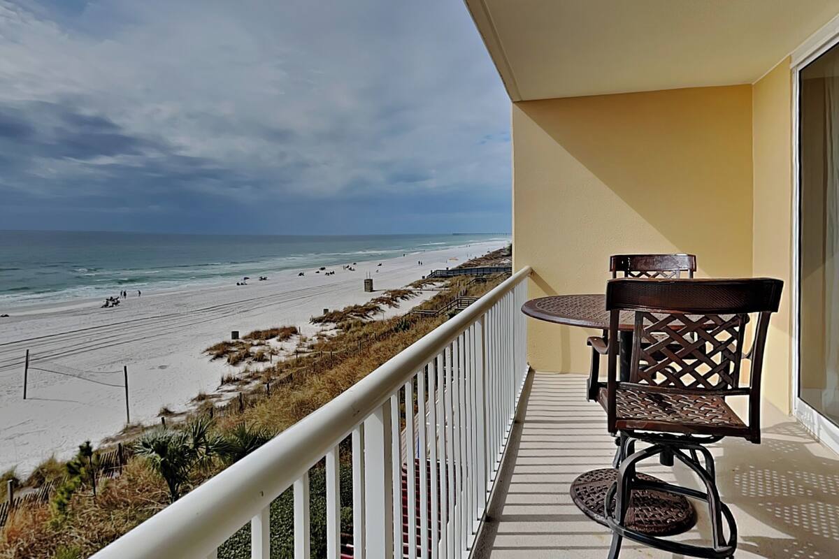 Ein Balkon mit Blick auf Strand und Meer.