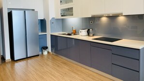 Eine moderne Küche mit weißen Schränken, einer Edelstahl-Spüle und einer schwarzen Arbeitsplatte.