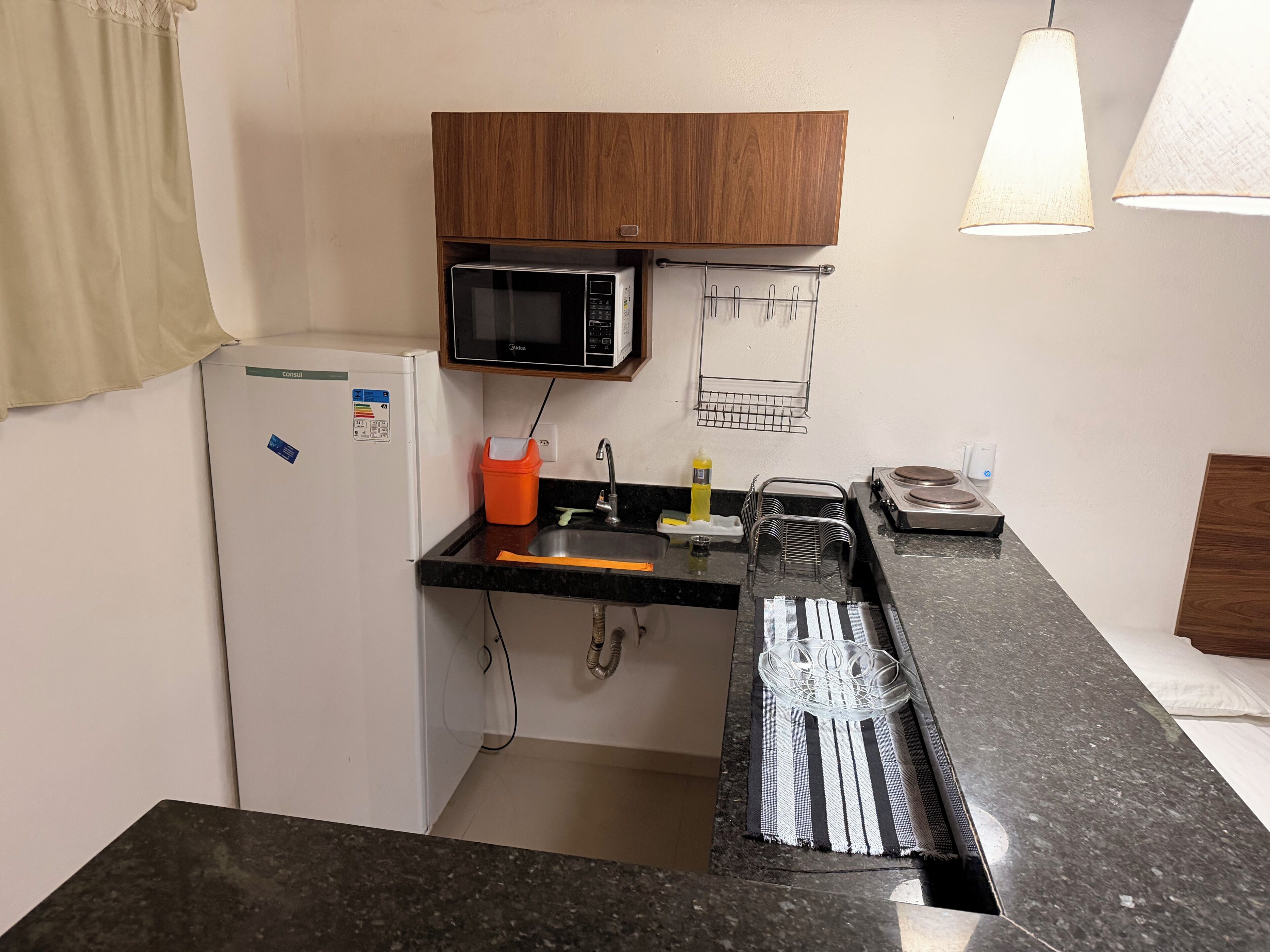Une cuisine compacte équipée d’un four à micro-ondes, d’un évier et d’un petit réfrigérateur.