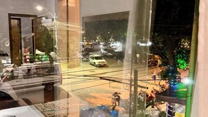 A view through a window with a glass reflection, a door, and a potted plant. - Pousada Portal do Mucugê (Porto Seguro)