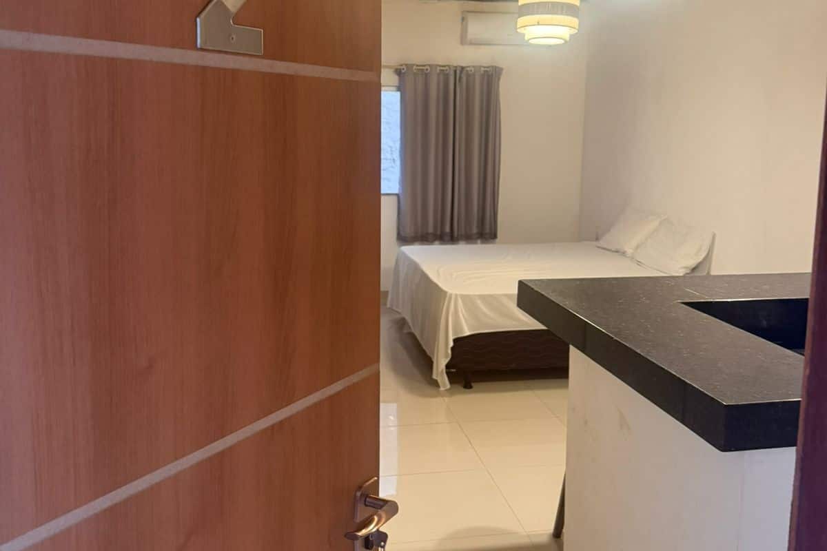 A room with a bed, a small kitchenette, and a wooden door with a number 2.