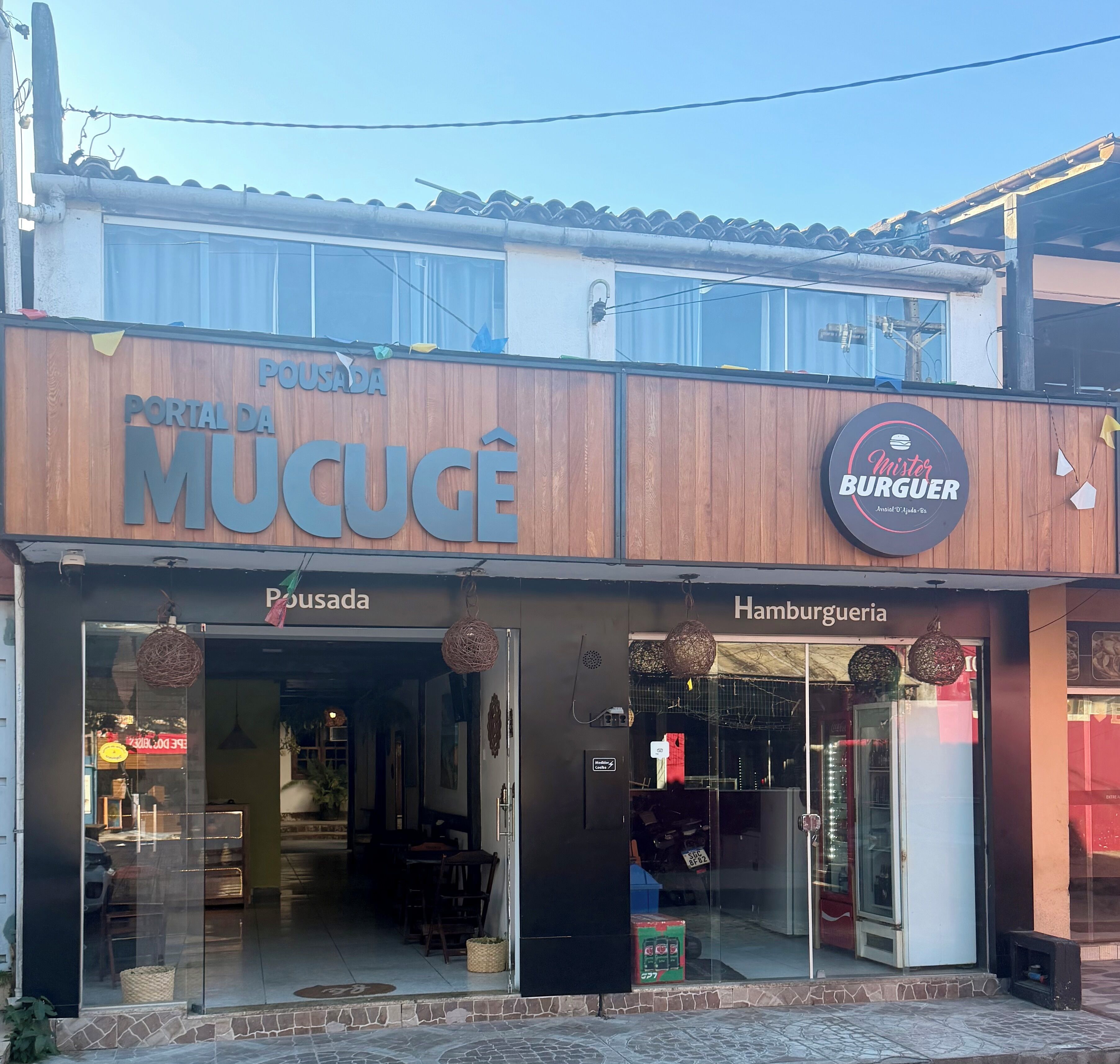 En butik med skiltning for 'Portal da Mucugê' og 'Mister Burguer'.