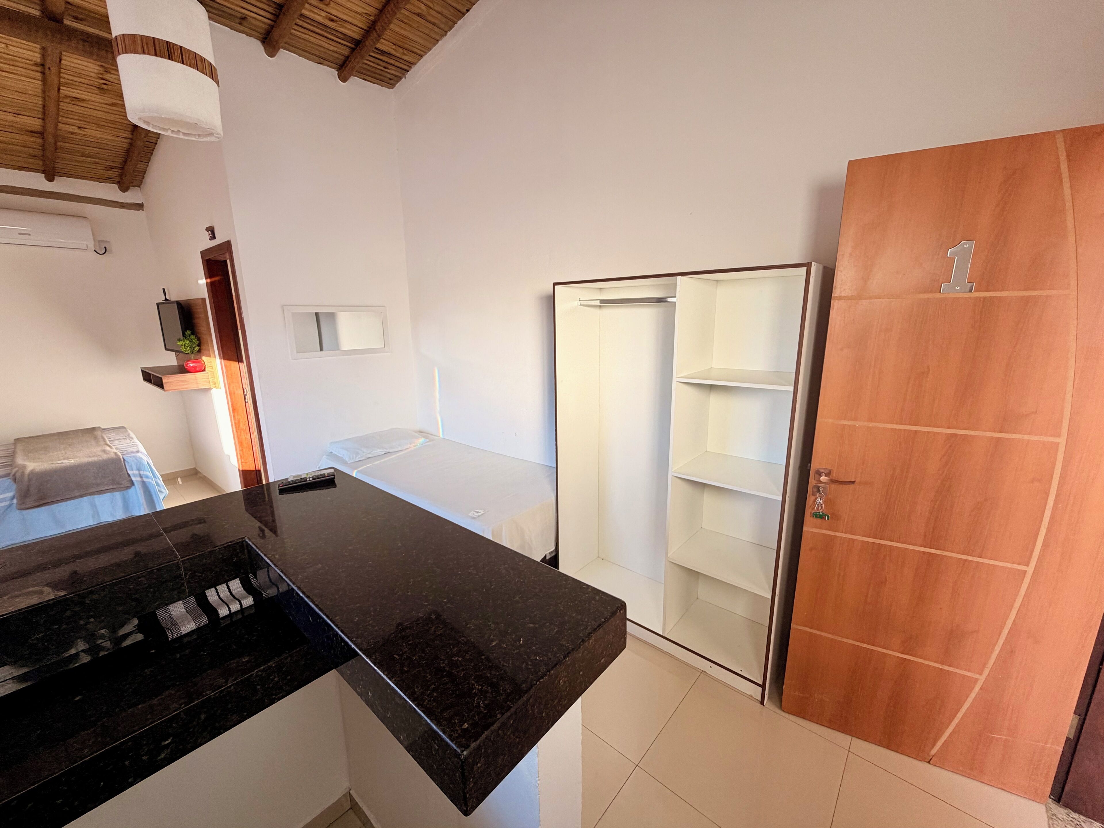 A bedroom with a bed, bedside table, and a wardrobe.