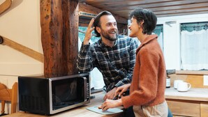 Une cuisine équipée d’un four à micro-ondes et de meubles de rangement en bois.