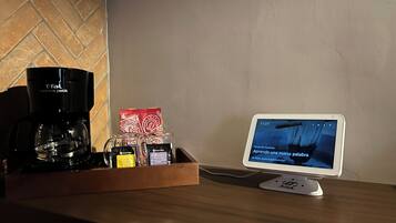 A coffee maker, a tray with coffee pods, and a tablet displaying a Spanish learning app.