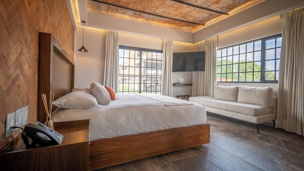 Un dormitorio moderno con una cama grande, un sofá y un televisor.
