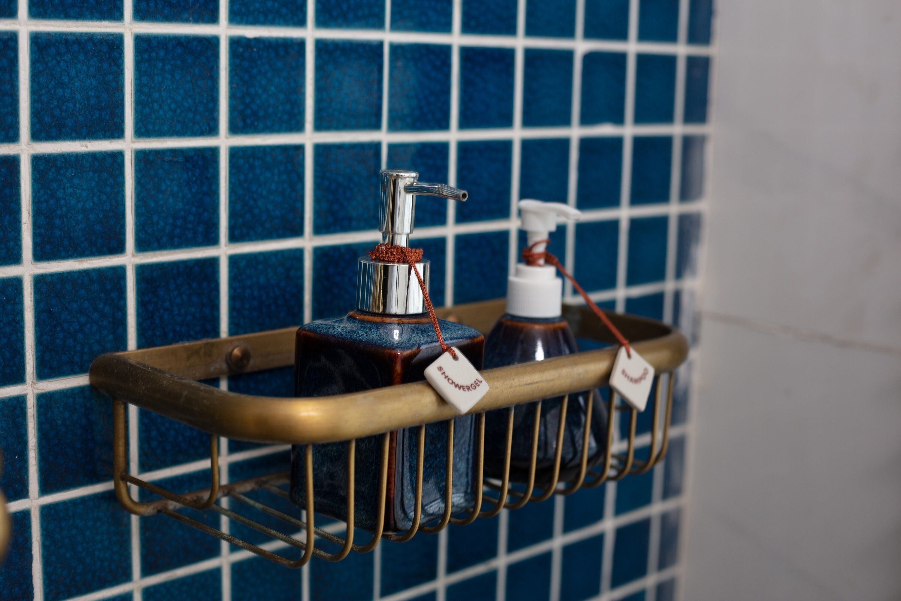 A bathroom shelf with a hand soap dispenser and a bottle of hand sanitizer.