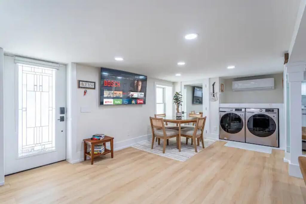 A modern kitchen with a dining area, built-in appliances, and a large window.