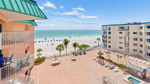 A hotel with a pool, beach view, and outdoor seating area. - Beach Cottages Ocean & Pool View Condo (Indian Shores)