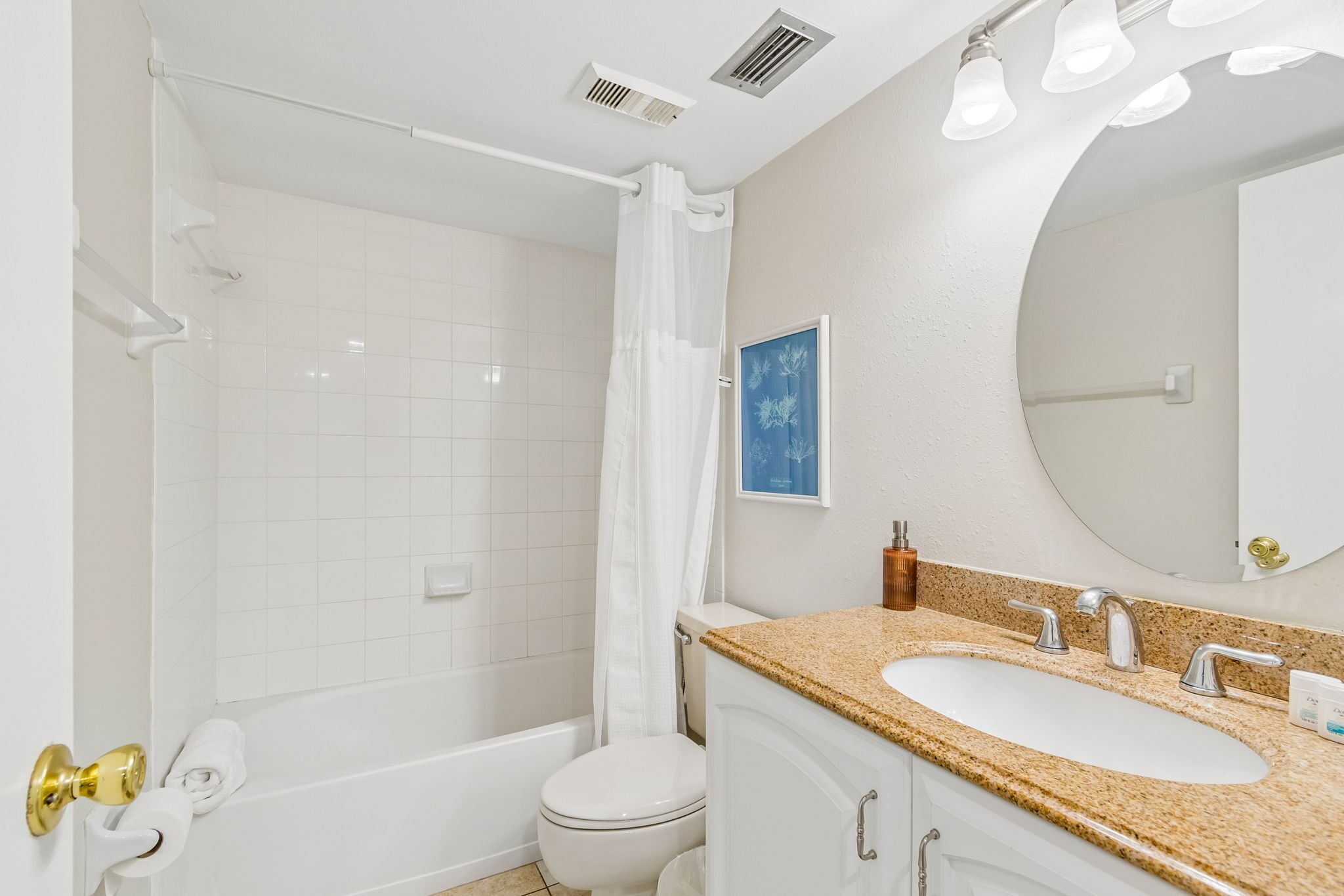 Une salle de bain avec une baignoire, des toilettes, un lavabo et un grand miroir.