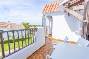 Enjoy dining or socializing on the balcony with a table and chairs, shaded by a pergola.