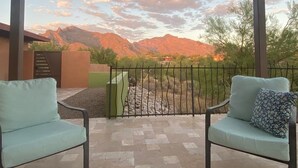 A patio with two light blue chairs and a green bench, overlooking a mountainous landscape with a clear sky. - NW Tucson family friendly house with Catalina mountain views (Tucson)