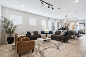 A modern living room with a sofa set, a coffee table, and a potted plant. - 5BD Windsor Island Private Pool  (WI 1900) (Davenport)