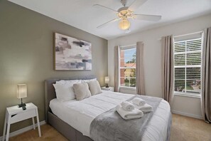 A hotel room with a bed, a ceiling fan, a window with curtains, and a painting on the wall. - 3BD Encantada Resort Near Parks (ER 3089) (Kissimmee)