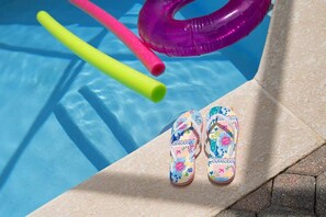 A poolside area with a pair of colorful flip-flops and two floating pool noodles. - 3BD Encantada Resort Near Parks (ER 3089) (Kissimmee)