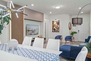 A modern living room with a dining area, a sofa set, a painting, and a lamp. - 5BD Windsor Island Star Wars Game Room (WI 3408) (Davenport)
