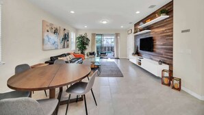 A modern living room with a dining table, sofa, and TV. - 7BD Windsor Westside Near Parks (WW 2485) (Four Corners)