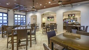 A restaurant with tables and chairs, ceiling fans, and a TV screen. - 7BD Windsor Westside Near Parks (WW 2485) (Four Corners)
