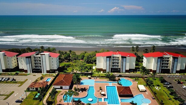 A resort with multiple buildings, a swimming pool, and a view of the ocean. - Oceanfront Balcony Condo 2101 | Playa Bejuco + Sunset Views + Pool (Bejuco)