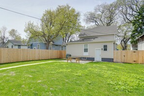 A residential property with a fenced backyard, a picnic table, and a small house with a front door and windows. - Dog-Friendly Home < 1 Mi to Downtown Fargo! (Fargo)