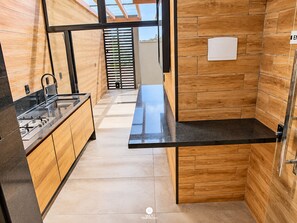 Una cocina moderna con armarios de madera, encimera negra y vistas al exterior.