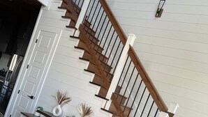 A staircase with wooden steps and white walls. - “Stay in this brand new luxurious cabin in Hochatown.  (Broken Bow)