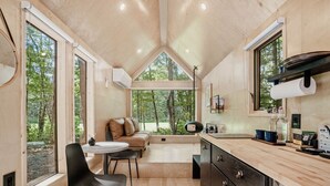 Una cocina moderna con ventanas amplias, comedor y una zona de estar acogedora.