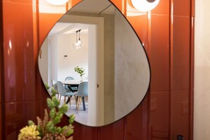 A round mirror reflecting a dining area with a table, chairs, and a hanging light fixture.