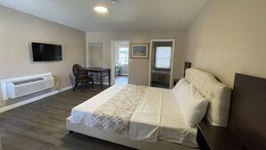 A bedroom with a bed, a desk, a chair, a television, and a window. - Elsinore Hot Springs & Lodge (Lake Elsinore)