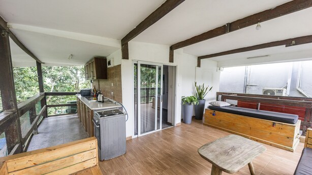 A spacious kitchen with wooden cabinets, a countertop, and a sliding glass door leading to a balcony.