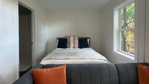 Une chambre à coucher avec un lit, une fenêtre et une porte.