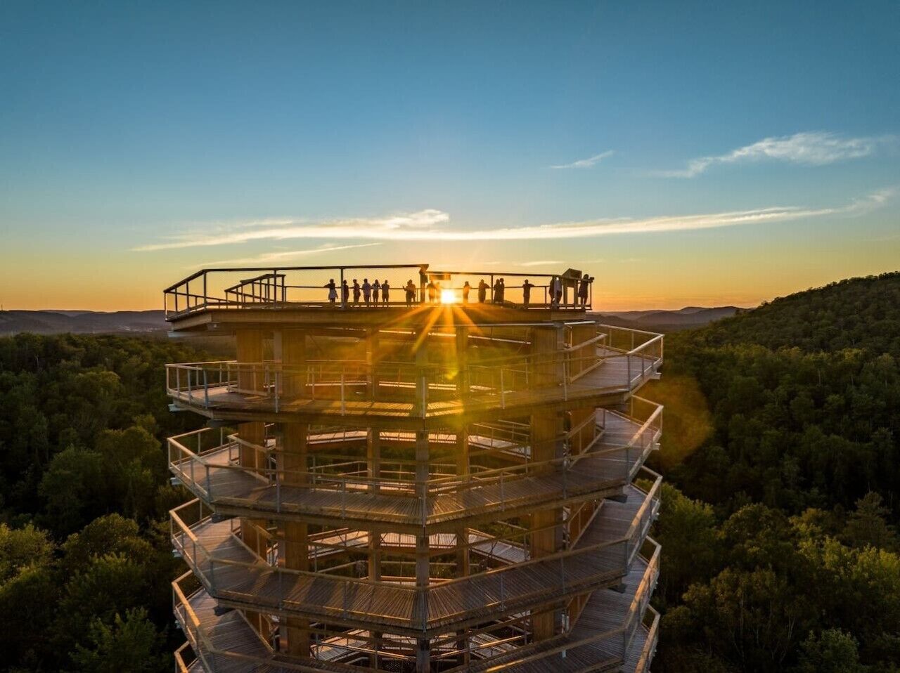 A multi-level observation tower with a panoramic view of the surrounding forest and distant landscape.
