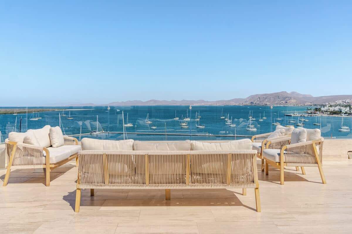 A terrace with wicker furniture and a view of the sea.