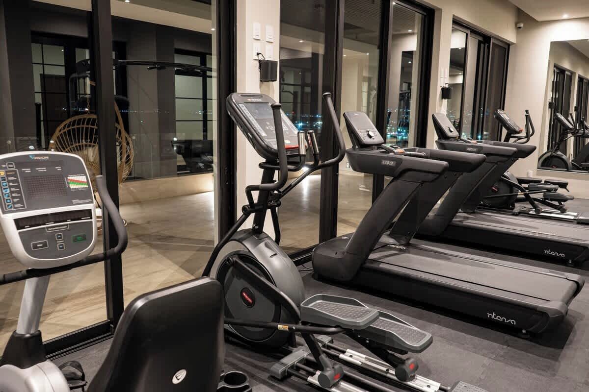 A gym with treadmills, a stationary bike, and a rowing machine.