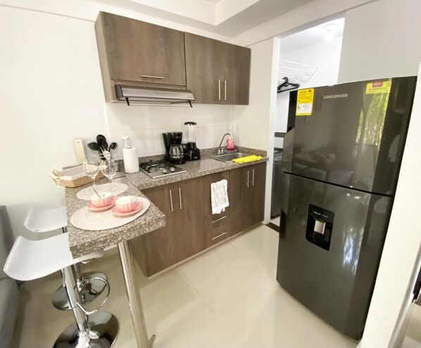 Refrigerador, cafetera y tetera, utensilios de cocina y isla de cocina 