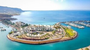 Um resort costeiro com marina, acesso direto à praia e um edifício central com vários andares.