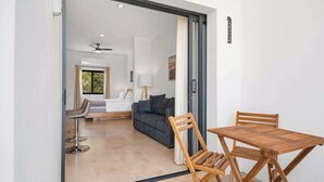 A modern interior with a wooden table and chairs, a sofa, and a ceiling fan. - Pineda Suite 202 with Parking (La Paz)