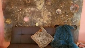A sofa with a decorative headboard featuring circular elements and a plush blue throw blanket. - Romantic Adobe Casita, Hot tub, Kitchen, Woodstove, astounding views, historic. (Los Cerrillos)