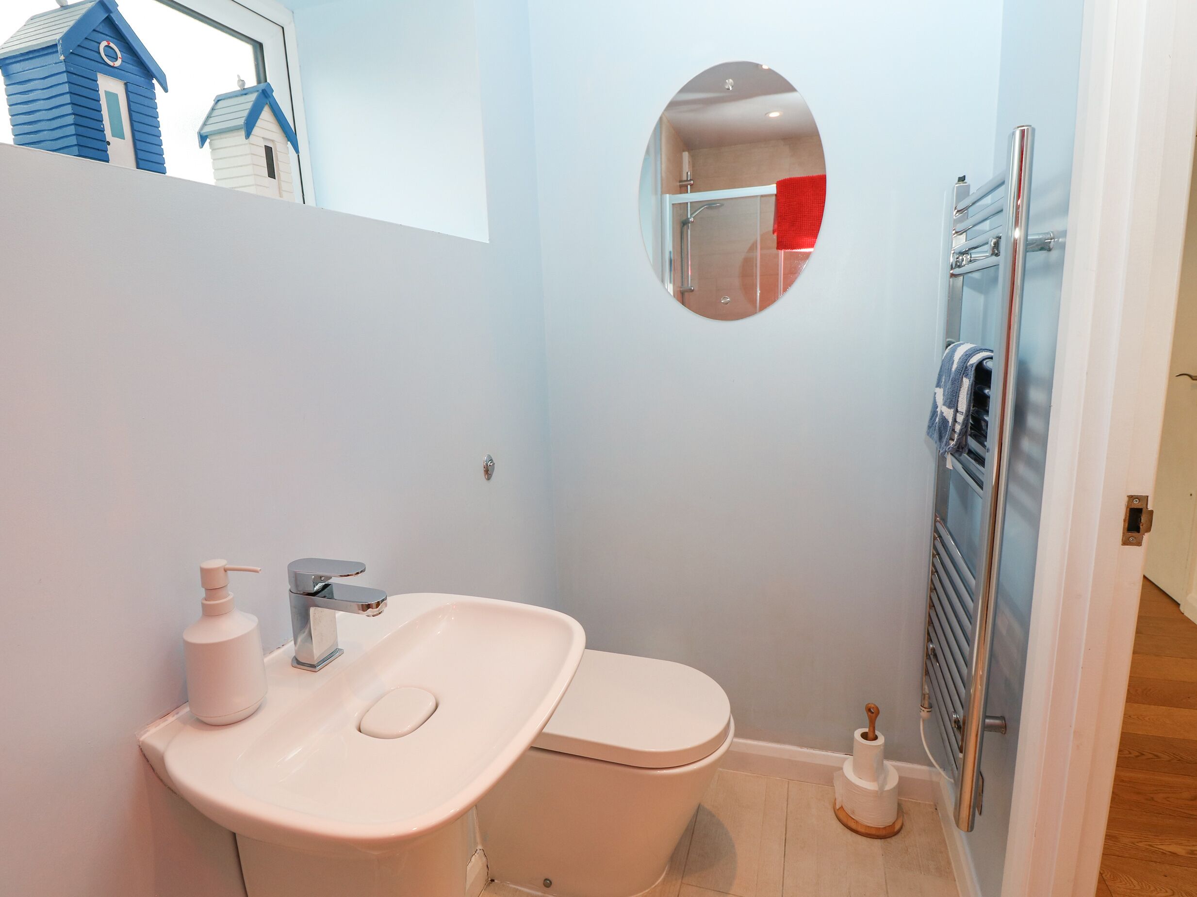 Een badkamer met een wastafel, toilet en spiegel.