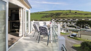 A balcony with a view of a green hill and a residential area. - Ocean Pearl (Kingsbridge)