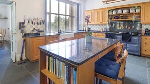 Una cocina moderna con una isla grande, armarios de madera y vistas al exterior.