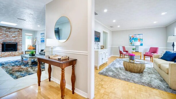 A spacious living room with a fireplace, a dining area, and a kitchen.