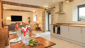 A modern kitchen with white cabinets, a wooden countertop, and a built-in oven. - Chequers Barn (Corsham)